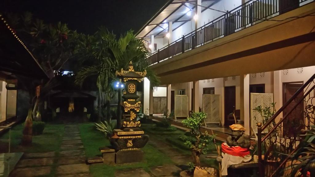 Una pasarela que conduce a un edificio por la noche en Puji Homestay en Mataram