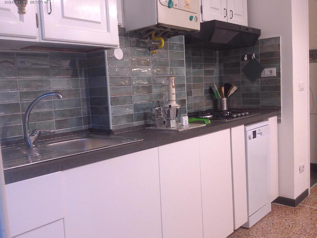 a kitchen with white cabinets and a sink at Casa di Alby in Rapallo