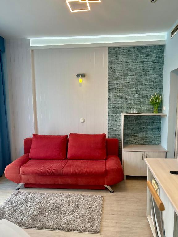 czerwona kanapa siedząca w salonie w obiekcie Hotel Négy Évszak w Hajduszoboszlo