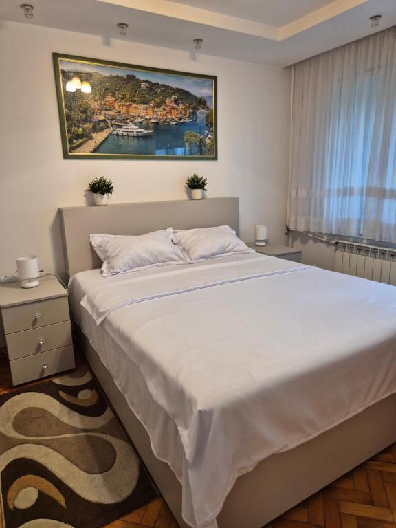 a bedroom with a large bed and a painting on the wall at Mika Premium Apartment Oradea - 2 bedrooms, Self Checkin in Oradea