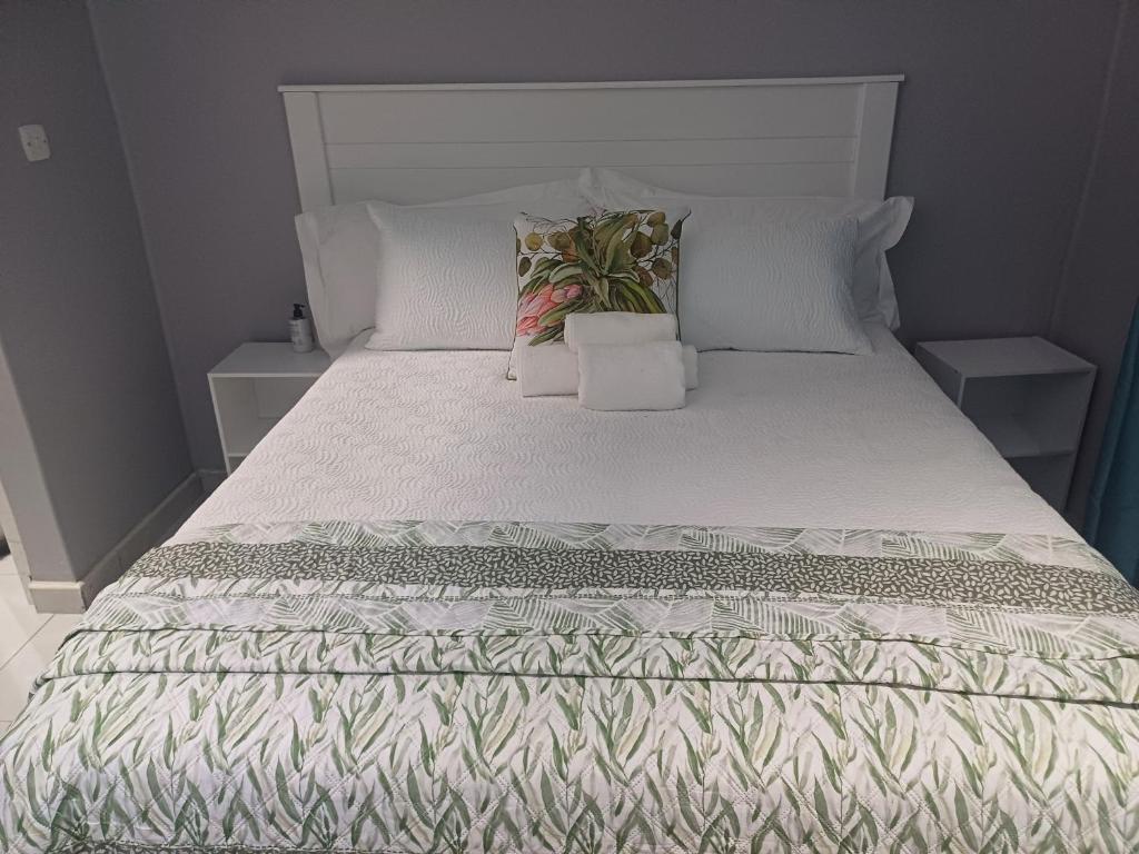 a bed with white sheets and pillows on it at Upendorest in Gaborone