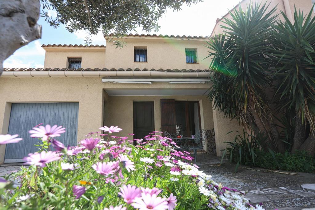 une maison avec un bouquet de fleurs devant dans l'établissement St Cyprien maison de vacances 6 personnes clim, à Saint-Cyprien