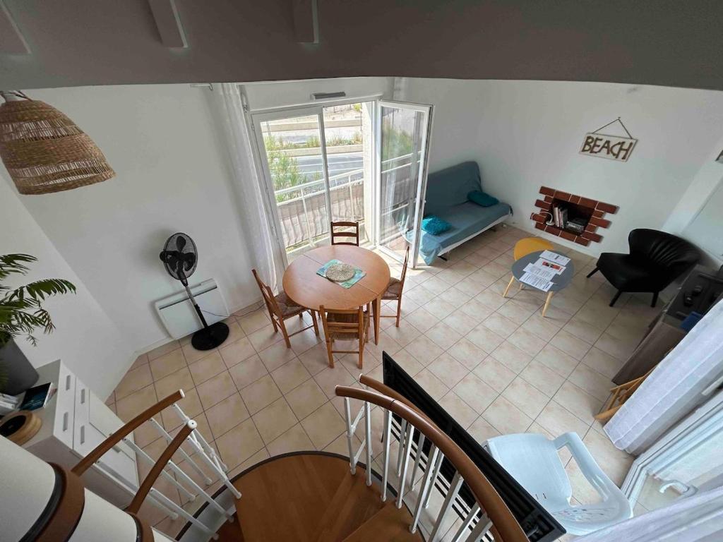 une vue aérienne d'un salon avec une table et des chaises dans l'établissement Maison front de mer, vue océan, à Soulac-sur-Mer