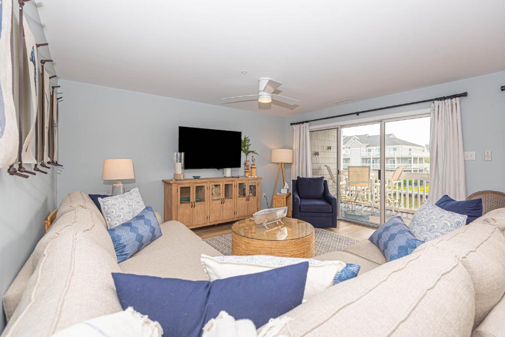 a living room with a couch and a tv at Tranquil 2-Bedroom Condo in Hidden Bay Relax & Enjoy Bay Views in Ocean City