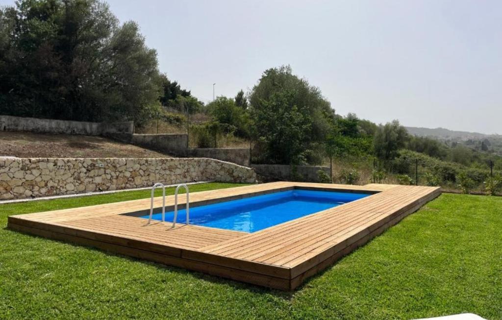 a swimming pool in a yard with a wooden deck at Villa con piscina a due passi da Siracusa in Canicattini Bagni