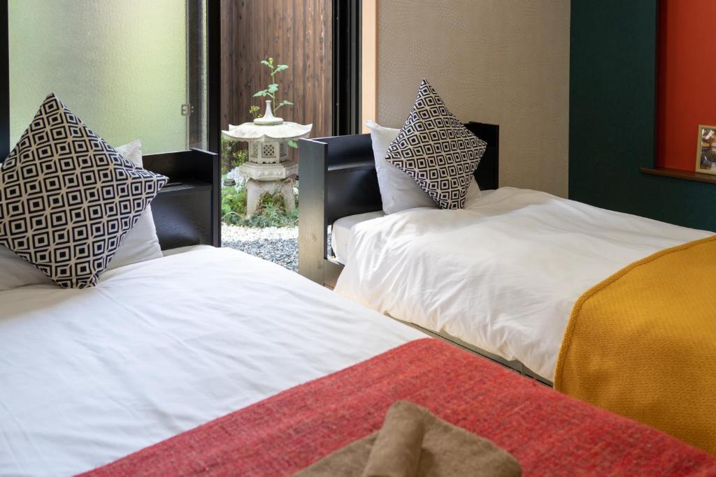 duas camas lado a lado em um quarto em nestay東九条01左側 em Quioto