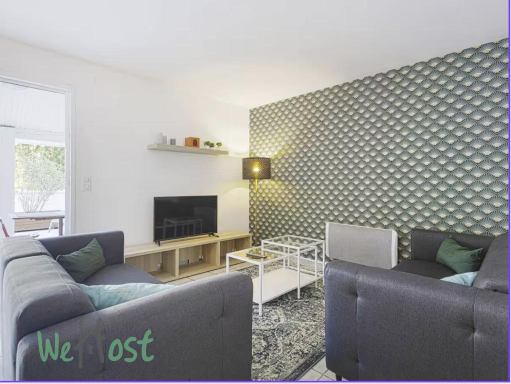 un salon avec deux canapés et une télévision dans l'établissement Laharie - CI - PB - Triplex 118m2 avec grande terrasse et parking, à Bayonne