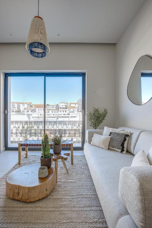 un salon avec un canapé et une grande fenêtre dans l'établissement Jessicannes - ALBA - Plage et Palais des Festival à pied, à Cannes