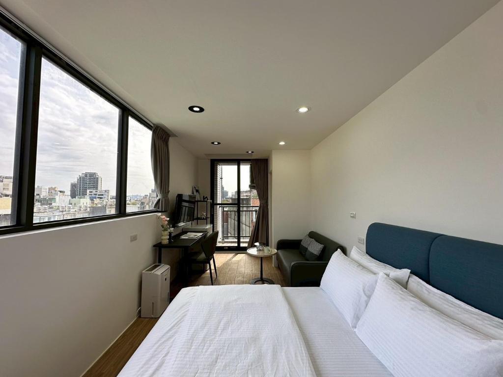 a bedroom with a bed and a large window at Neostay in Zhubei