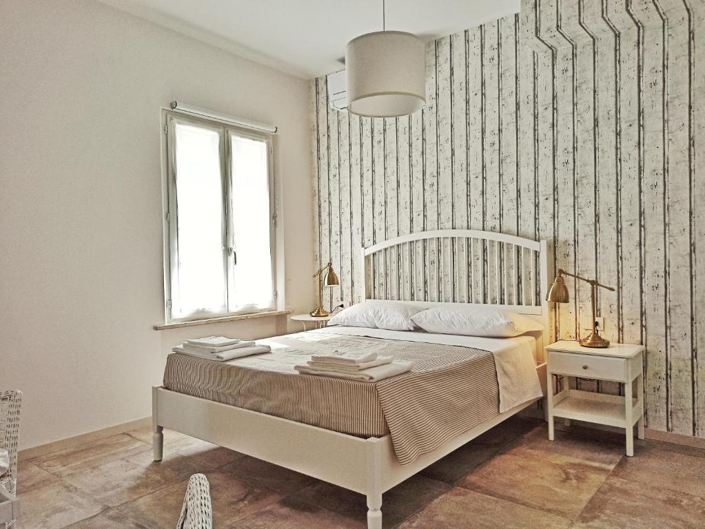a white bedroom with a bed and a window at Colleoni 19 in Civitanova Marche