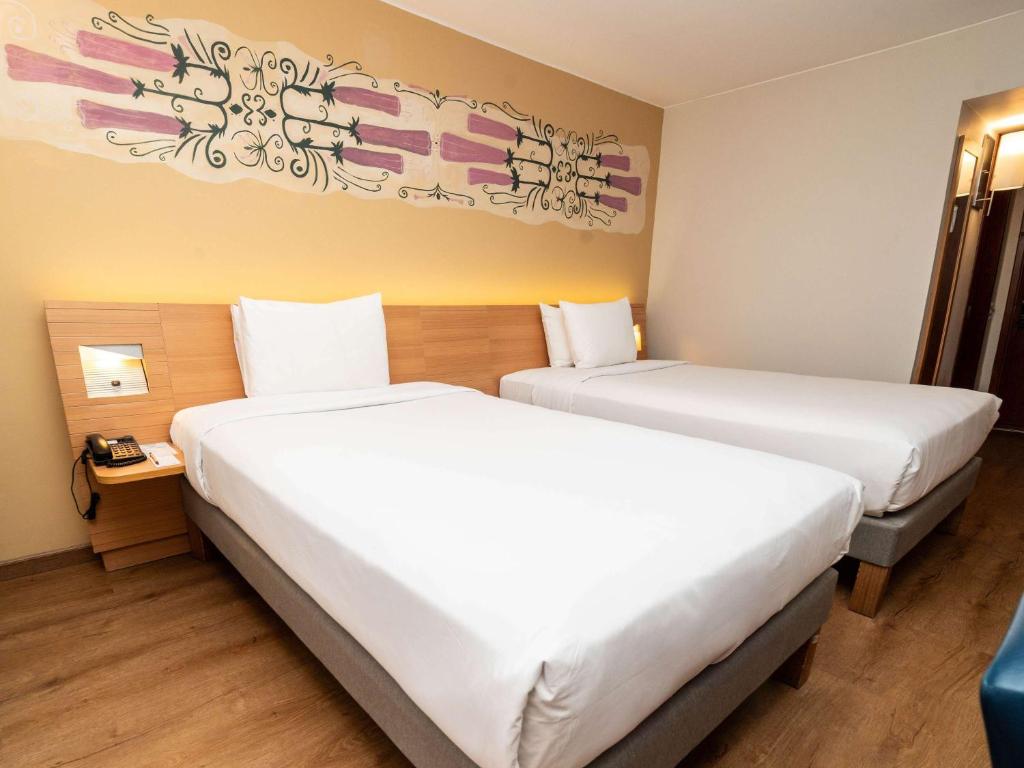 Postel nebo postele na pokoji v ubytování Novotel Cusco