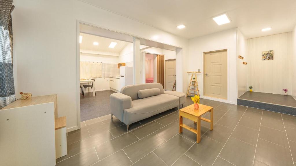 una sala de estar con un sofá y una mesa en Sokcho Seohyeon Ine Pension, en Sokcho