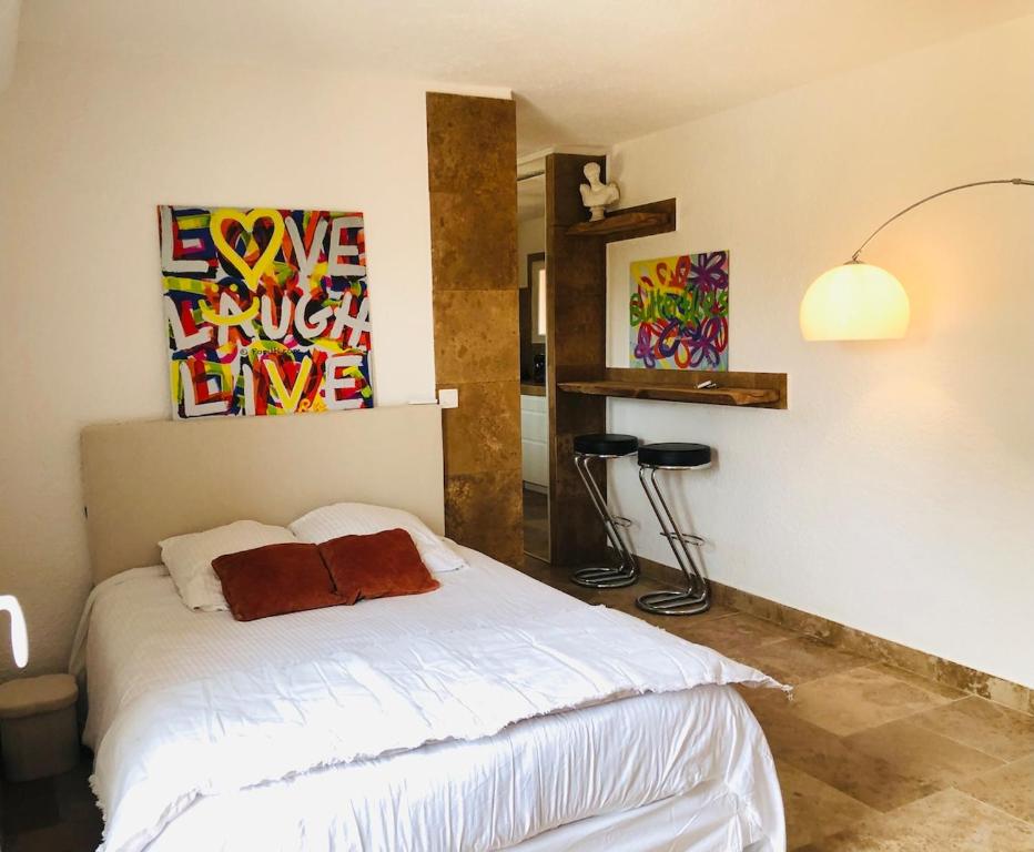 une chambre avec un lit et un tableau au mur dans l'établissement Charmant studio, à Saint-Tropez