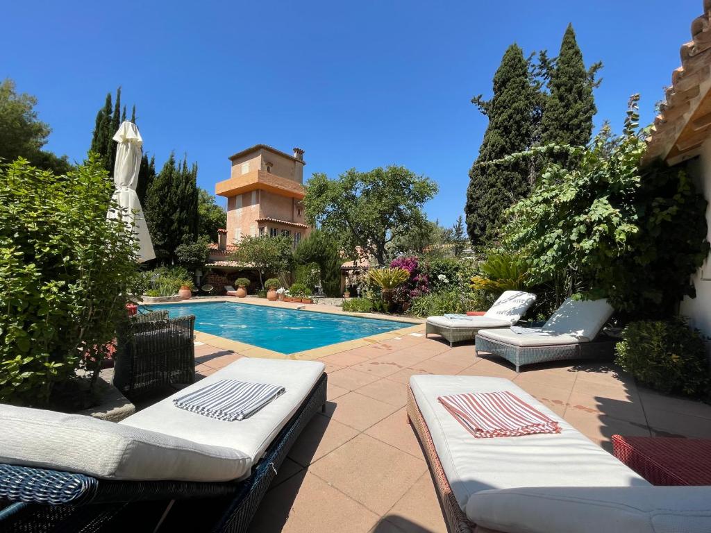 a swimming pool with chaise lounge chairs next to a building at La dépendance du Clos de la tour Cassis in Cassis