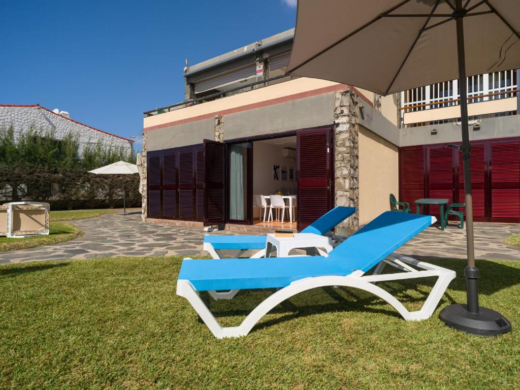 ein paar blau-weiße Stühle und ein Sonnenschirm in der Unterkunft Ciaboga Front Line By CanariasGetaway in San Agustín