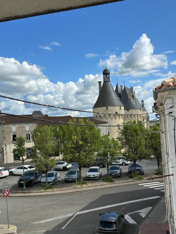 un bâtiment avec des voitures garées dans un parking dans l'établissement Studio du Château, à Jonzac