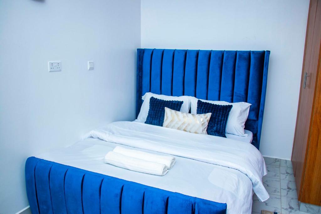 a blue bed with white sheets and pillows at Adristar Homes Ruiru Membley in Ruiru