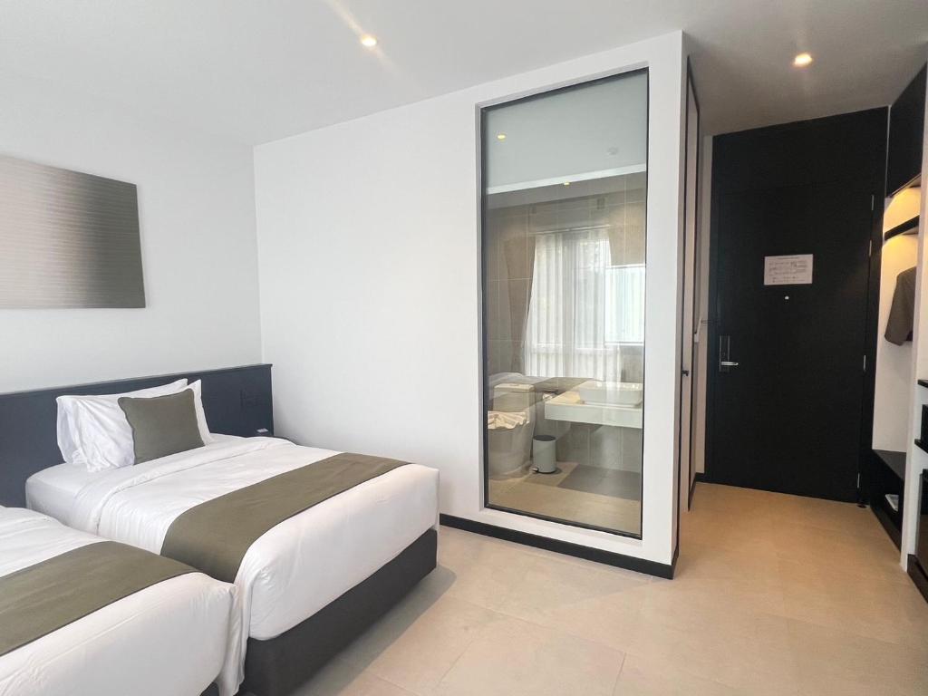 Postel nebo postele na pokoji v ubytování Hotel Whitt Hua Hin