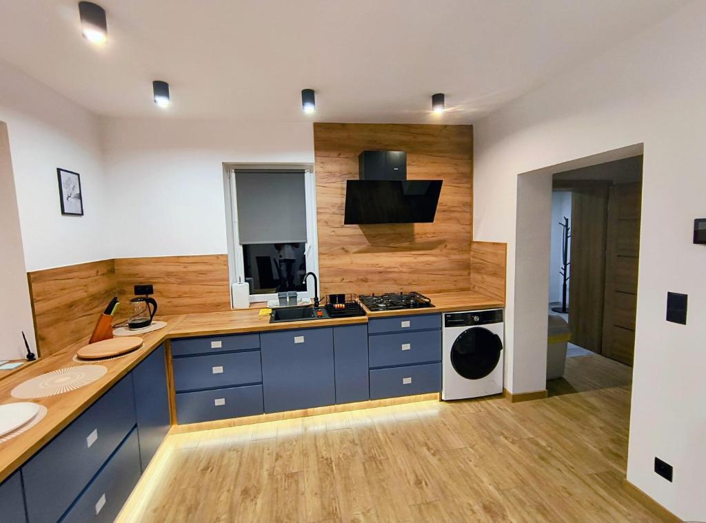 a kitchen with blue cabinets and a sink and a stove at Józefinka House of Energylandia Zator in Spytkowice
