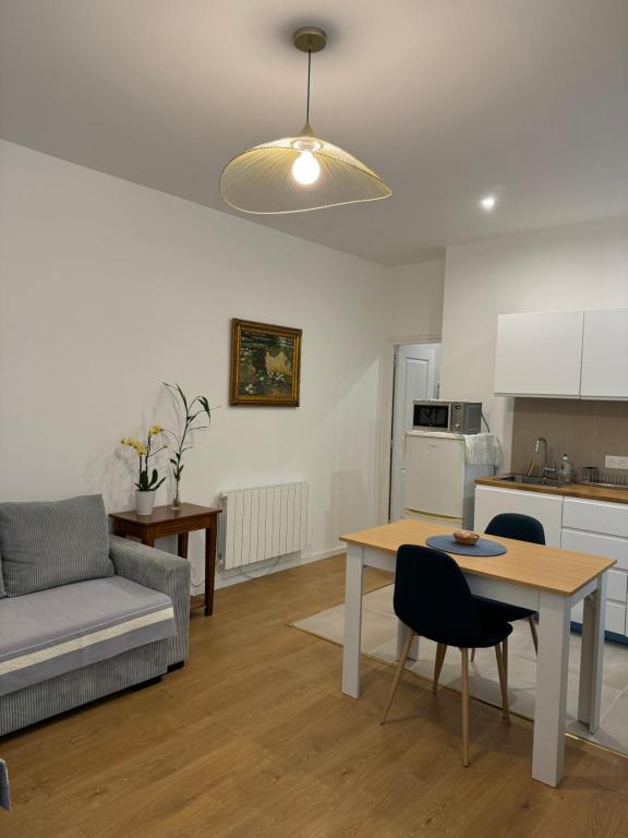 un salon avec une table et un canapé dans l'établissement Appartement meublé tout confort, à Chalon-sur-Saône