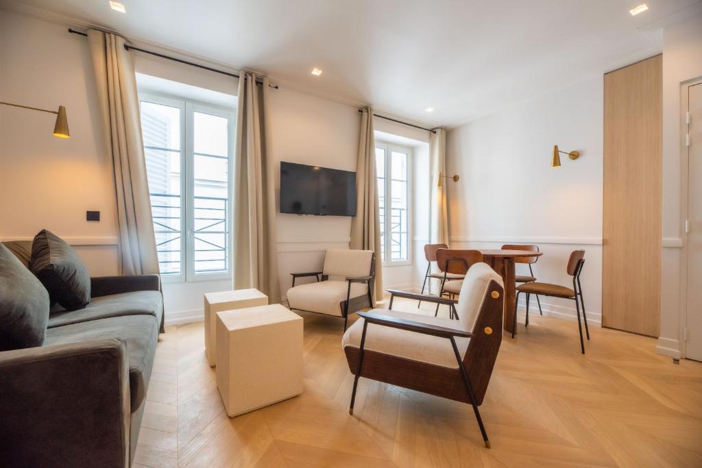 un salon avec un canapé, des chaises et une table dans l'établissement 1 Bedroom Flat - Crémieux, Bastille, à Paris