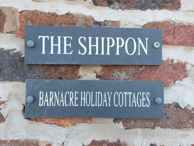 two signs on the side of a brick wall at The Shippon Barn - A delightful haven for families in Wirral