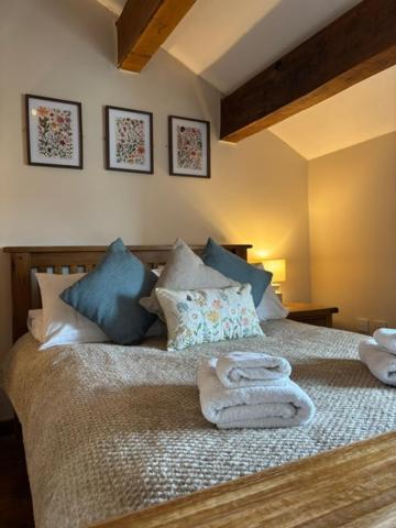 a bedroom with a bed with towels on it at The Shippon Barn - A delightful haven for families in Wirral