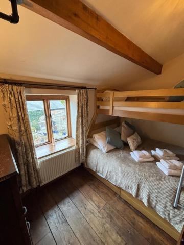 a small bedroom with a bed and a window at The Shippon Barn - A delightful haven for families in Wirral