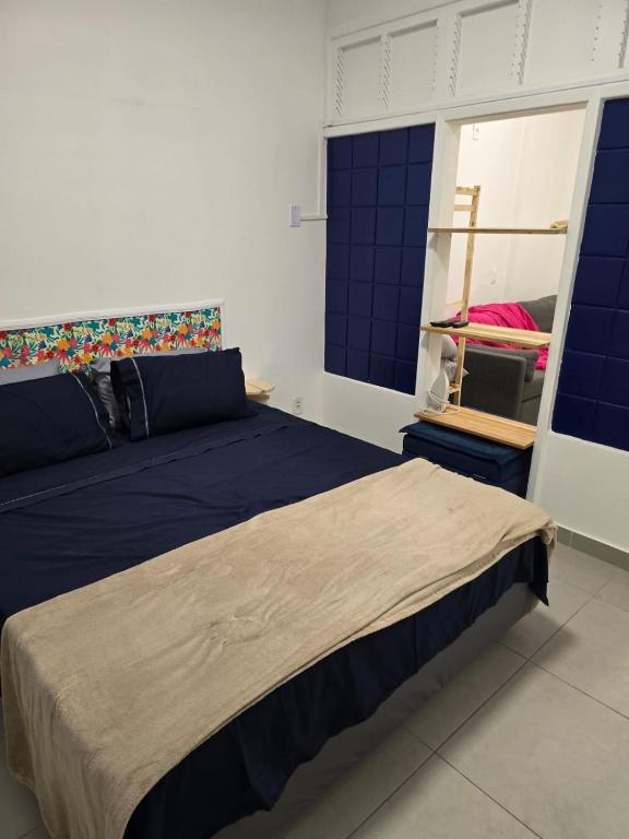 a bedroom with a large bed with blue sheets at 100m da praia de Copacabana in Rio de Janeiro
