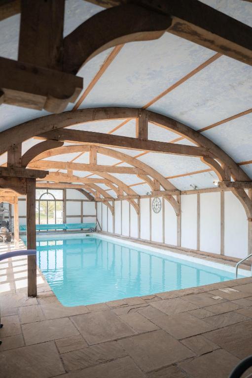a large indoor swimming pool with a ceiling at The Shippon Barn - A delightful haven for families in Wirral