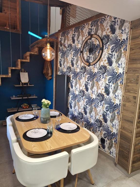 une salle à manger avec une table en bois et des chaises blanches dans l'établissement Appartement de charme rénové 