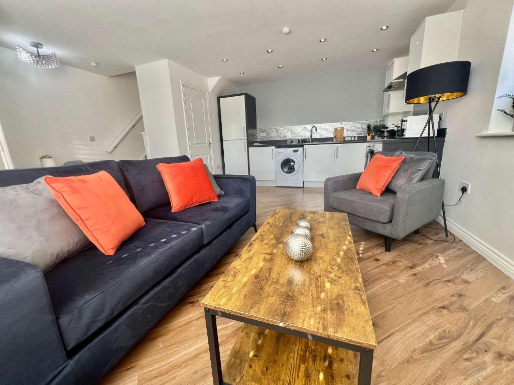 a living room with a black couch and a table at Swan House in Pallion