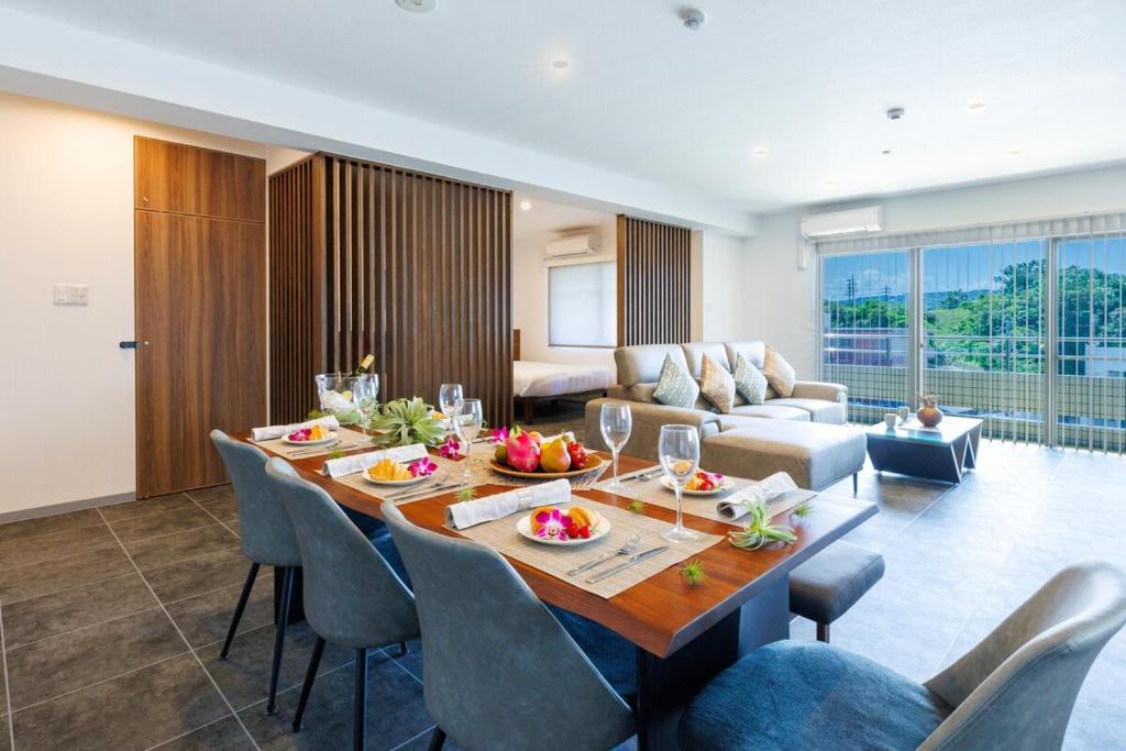 un salon avec une table et un canapé dans l'établissement Walking distance to the beach & full of gourmet spots! Up to 8 people, free parking for 2 cars コーディアルステイA2, à Onna