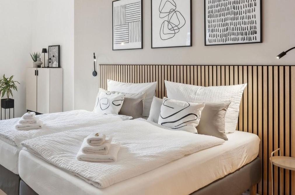 a bedroom with a large white bed with towels on it at kitchenroombed - Top City-Lage I nahe Hbf I bis 5P I Aufzug I Tiefgarage I Terrasse in Halle an der Saale