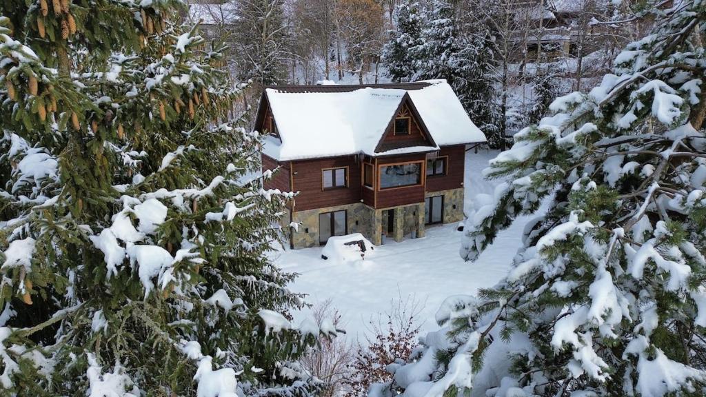a log cabin in the snow with snow covered trees at Gorczańska Chata Lubomierz in Lubomierz