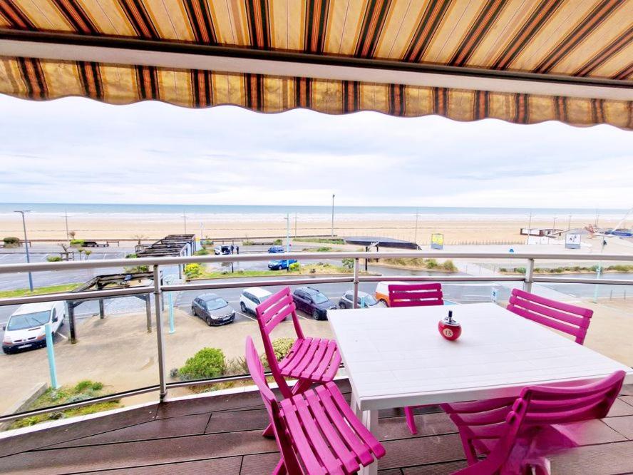 une table et des chaises sur un balcon avec vue sur la plage dans l'établissement Grand balcon face mer appartement 2 chambres rénové, à Saint-Jean-de-Monts