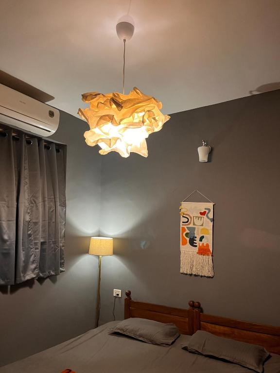 a room with a bed and a light hanging from the ceiling at Surreal Mountain View Studio in Canacona