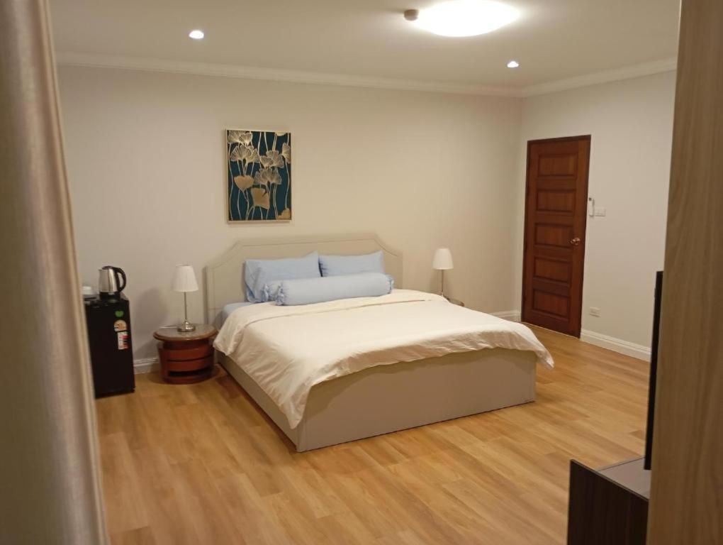 a bedroom with a bed and a wooden floor at Waterfront Royal Villa in Bang Pakong