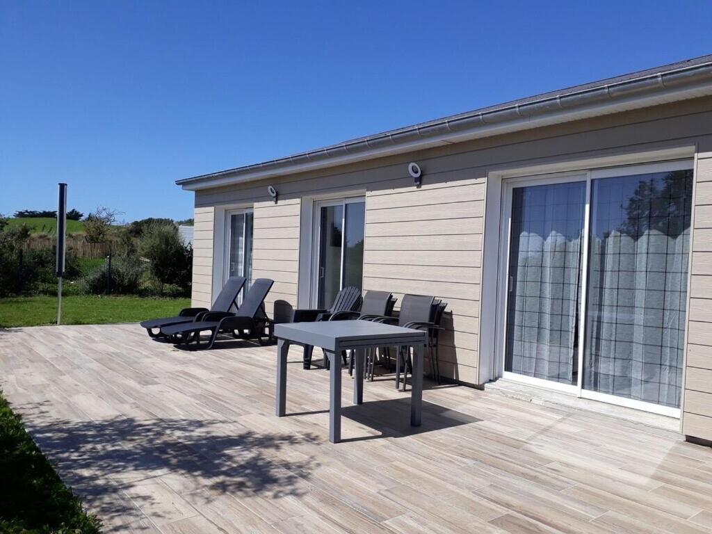 un patio avec une table et des chaises devant une maison dans l'établissement Dunes d'Hattainville, à Les Moitiers-dʼAllonne