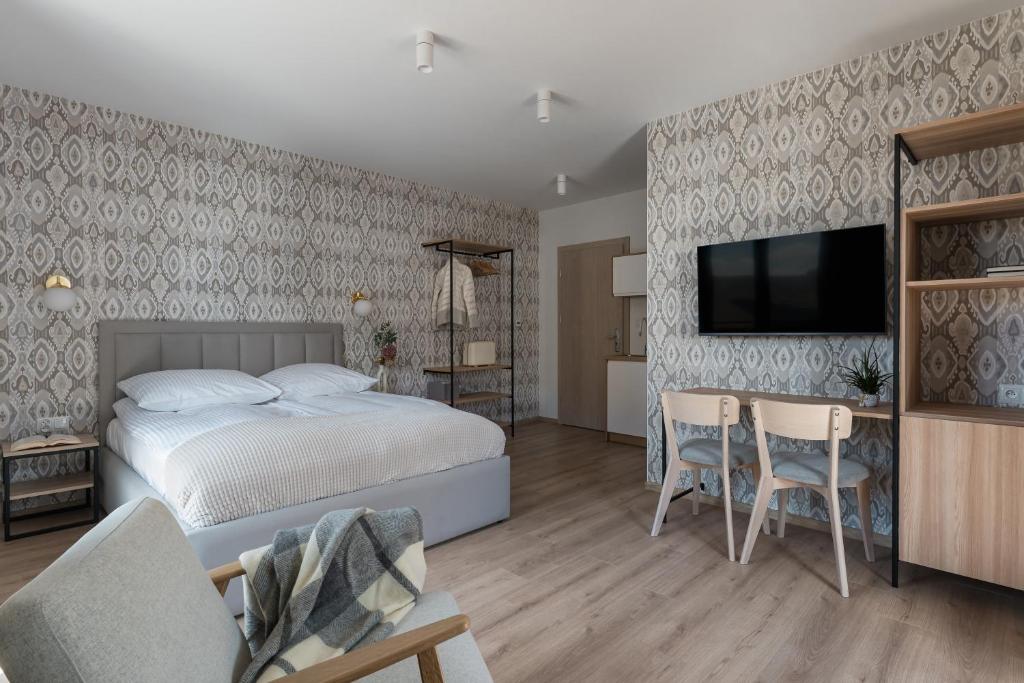 a bedroom with a bed and a flat screen tv at Orchidea Willa Pienińska in Sromowce Wyżne