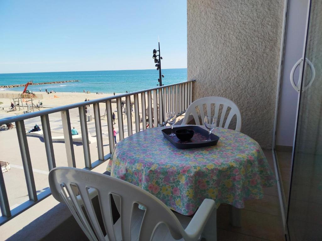 une table sur un balcon avec vue sur la plage dans l'établissement Plage, commerces et animations pour ce T2 avec parking privatif -5AT30, à Saint Cyprien Plage