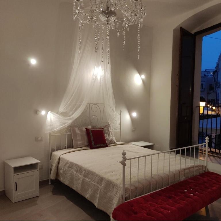 - une chambre avec un lit blanc et un lustre dans l'établissement La casa di Giusy, à Bari