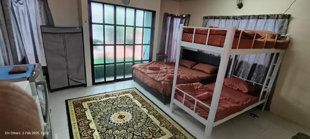 een slaapkamer met 2 stapelbedden en een tapijt bij Din others roomstay in Kuala Terengganu