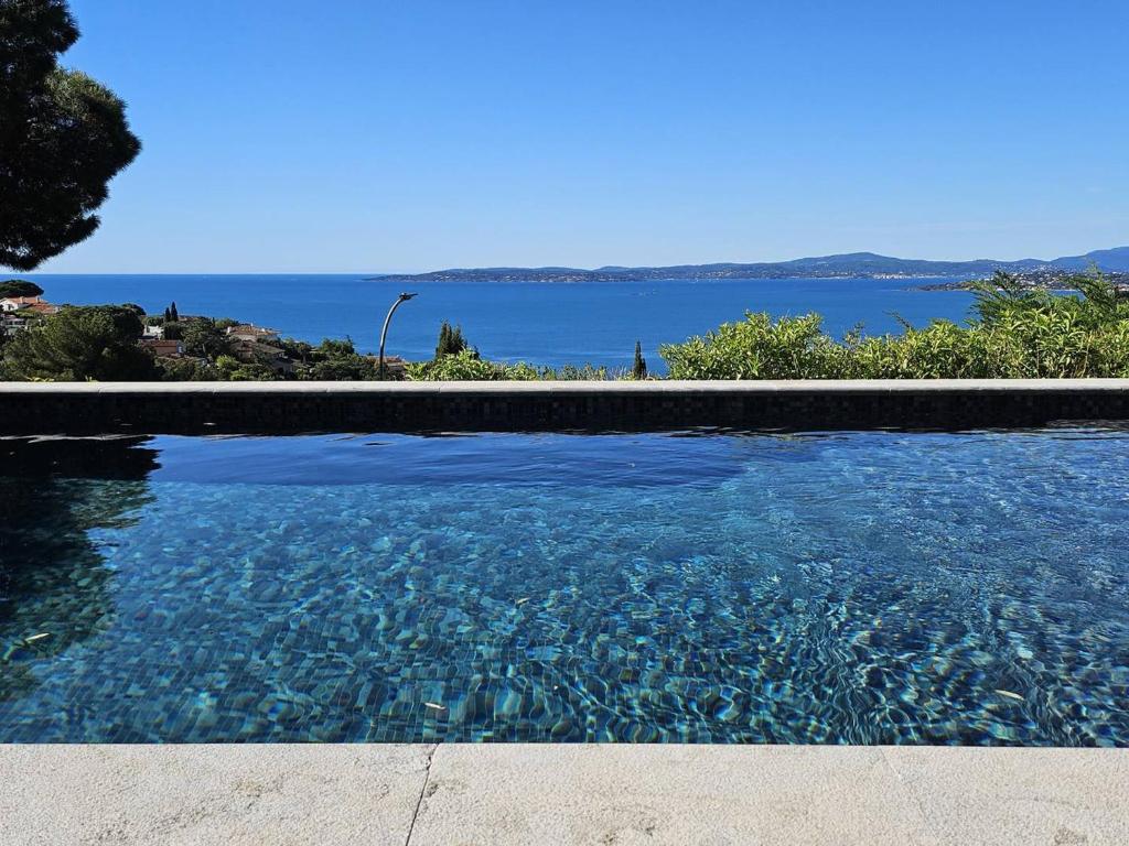une piscine avec vue sur l'eau dans l'établissement Villa de maître avec piscine privée pour 14 personnes, climatisation et animaux admis - FR-1-768-62, aux Issambres