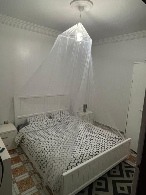 1 dormitorio con cama blanca y mosquitera en Appartement kasbah, en Tánger