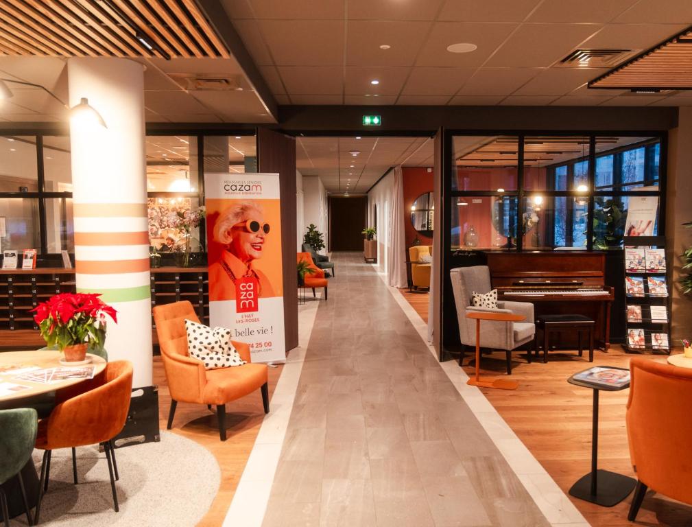 un hall d'un magasin avec des chaises et des tables dans l'établissement Résidence CAZAM L'HAY LES ROSES, à Chevilly-Larue