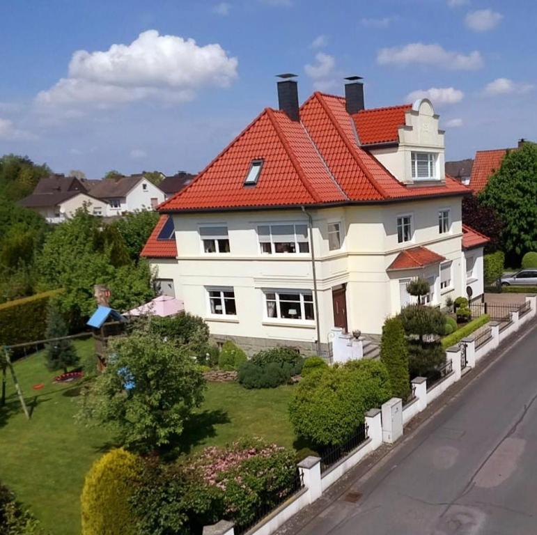 une grande maison blanche avec un toit orange dans l'établissement Ferienwohnung Alte Post Retzen, à Bad Salzuflen