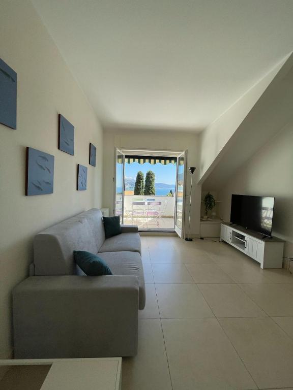 a living room with a couch and a television at Blue horizon retreat-Luxury Penthouse in Rapallo