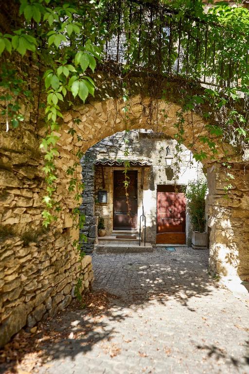 - l'entrée d'un bâtiment en pierre avec une arche dans l'établissement Maison Florence, à Valliguières