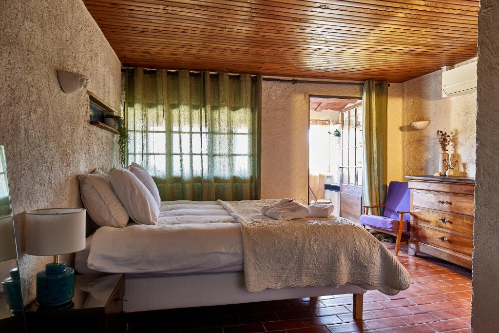 a bedroom with a bed with a cat laying on it at Maison Florence in Valliguières